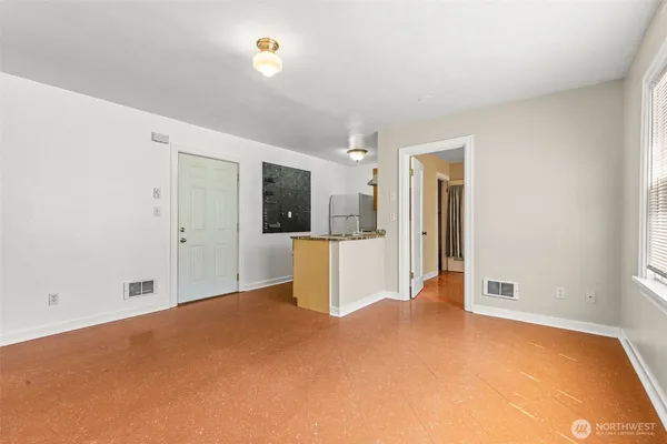 an empty room with kitchen view