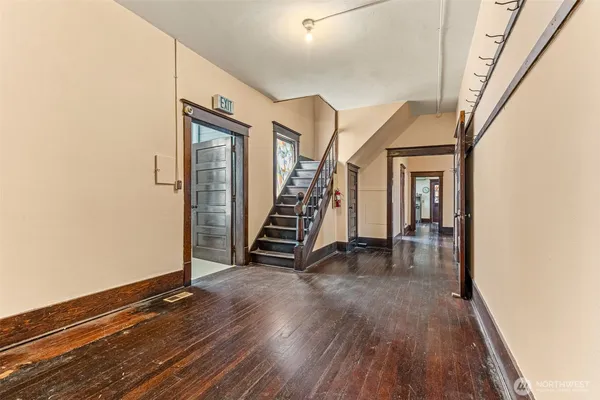 a view of a hallway with wooden floor and staircase