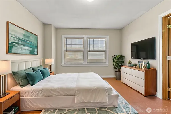 a bedroom with a large bed and a flat screen tv