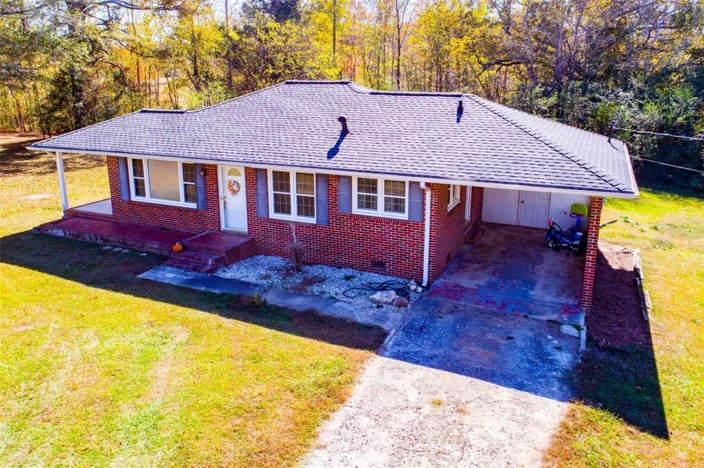 76 Lively Road Waco, GA 30182 - Photo 1 of 1 a backyard of a house with table and chairs under an umbrella