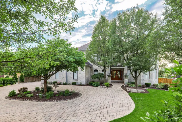 a front view of a house with a yard and trees
