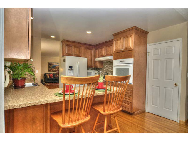 807 Haverhill Drive Sunnyvale, CA 94087 - Photo 11 of 20 a kitchen with stainless steel appliances kitchen island granite countertop a refrigerator a stove a sink dishwasher with a dining table and chairs with wooden floor