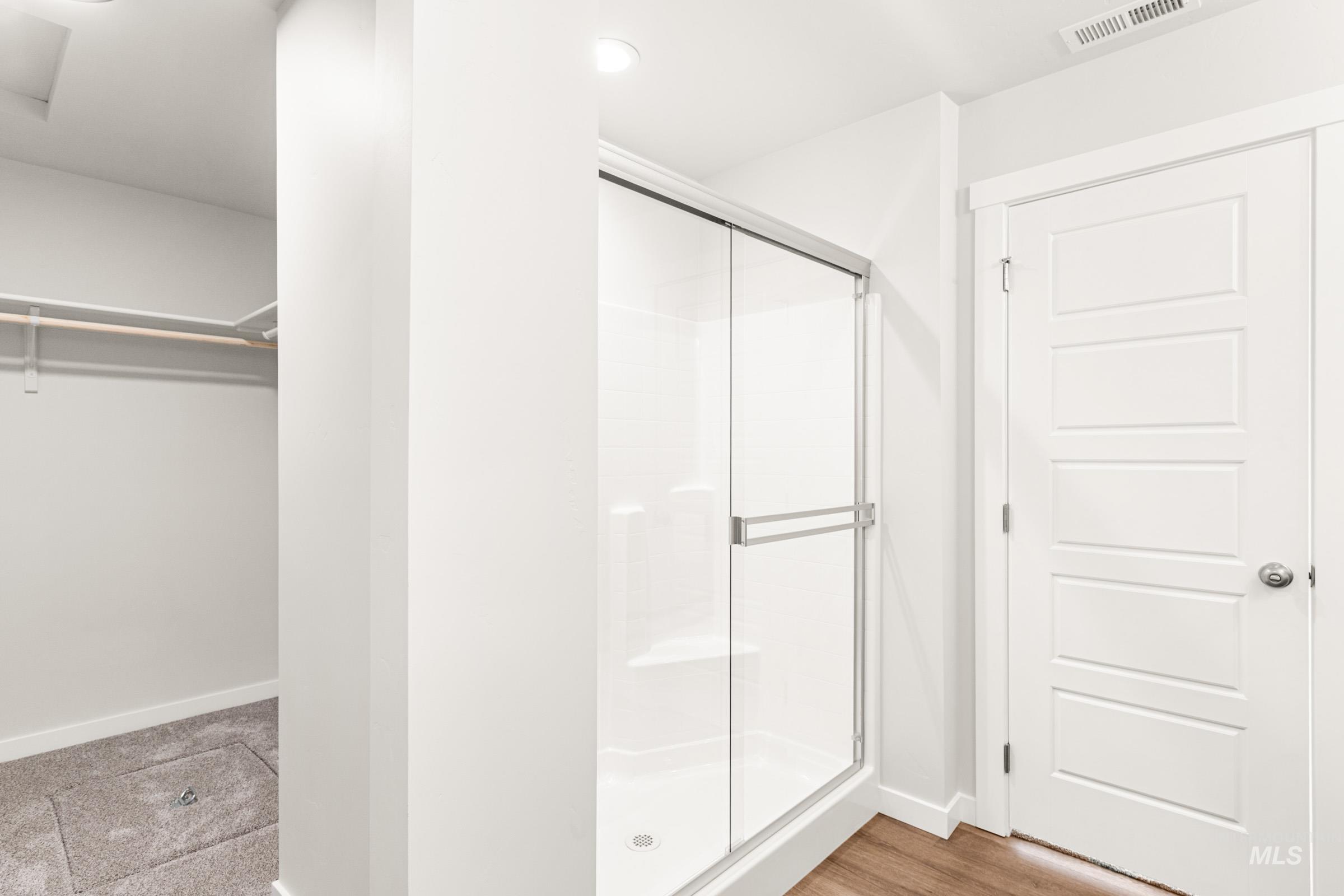 1077 West Jasper Street Meridian, ID 83642 - Photo 19 of 19 Glass-enclosed shower with white surround, recessed lighting, and a contemporary five-panel door