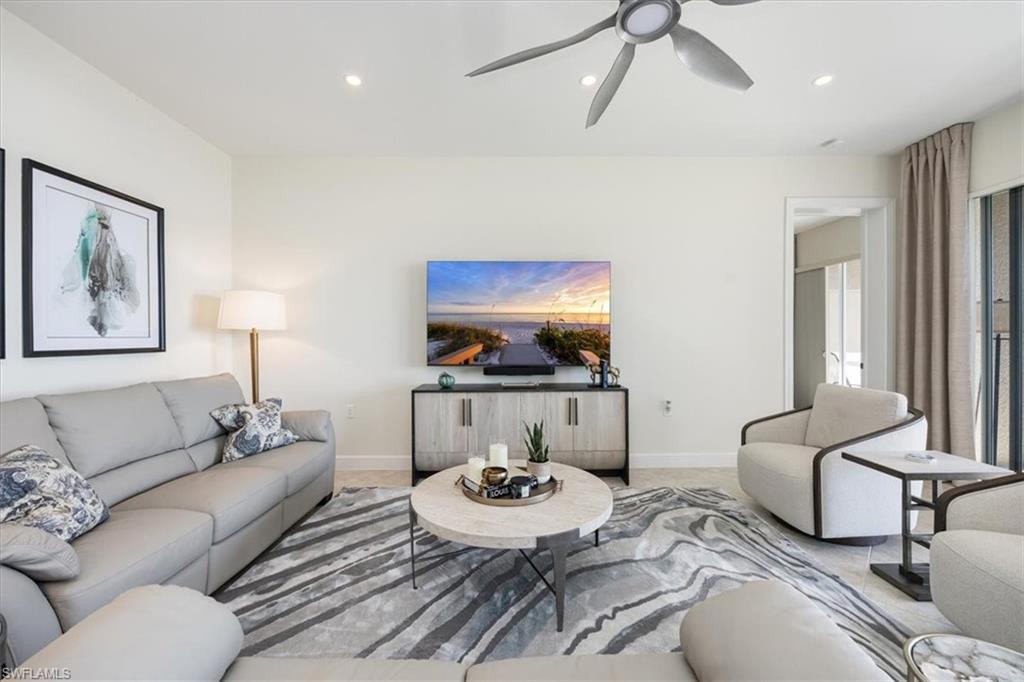730 Regency Reserve Circle, Unit 2802 Naples, FL 34119 - Photo 5 of 22 a living room with furniture and a flat screen tv
