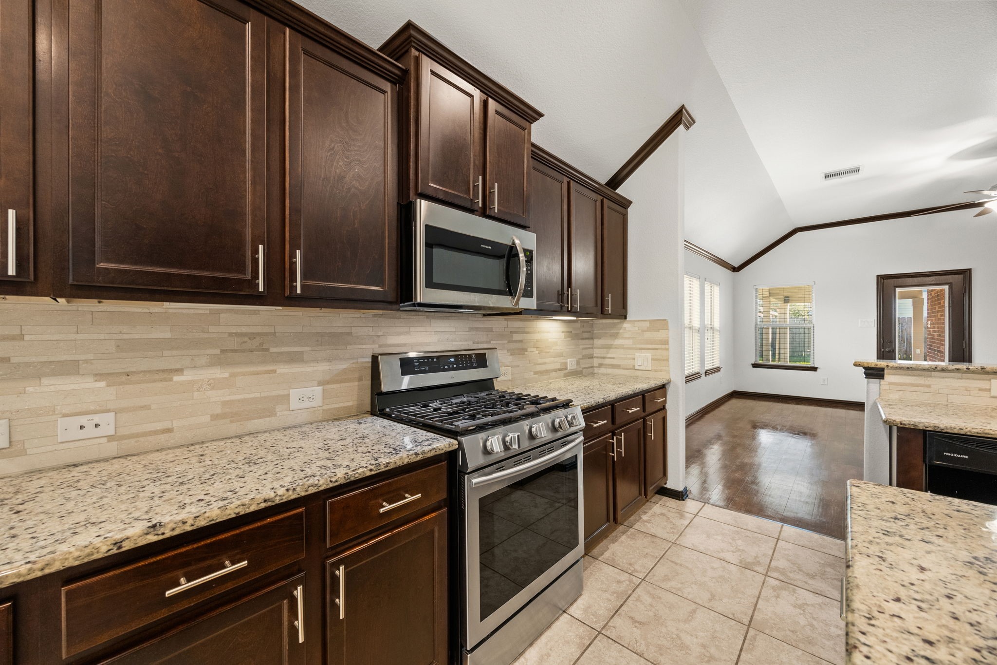 4342 Ambrosia Lane Baytown, TX 77521 - Photo 12 of 34 a kitchen with stainless steel appliances granite countertop a stove and a microwave