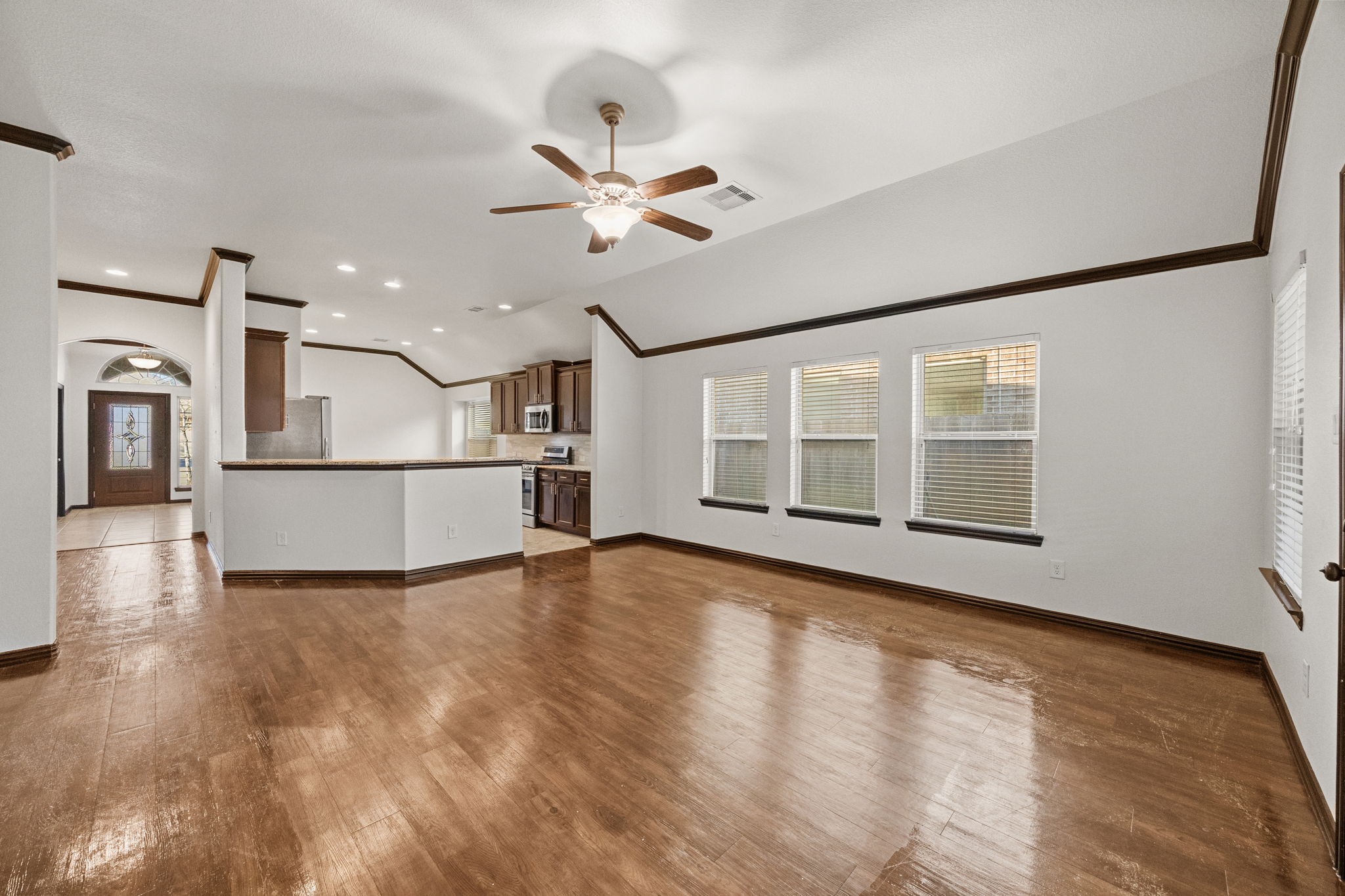 4342 Ambrosia Lane Baytown, TX 77521 - Photo 13 of 34 a view of a big room with wooden floor a ceiling fan and windows