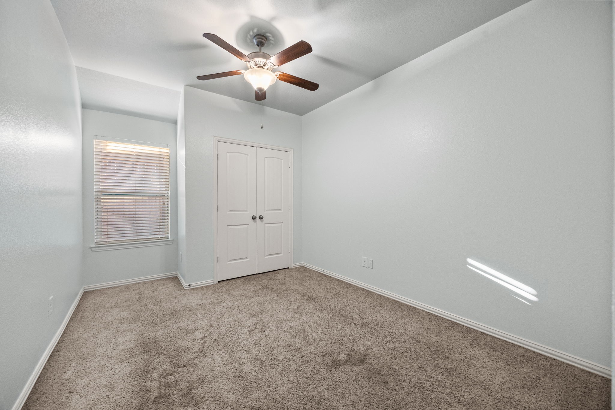 4342 Ambrosia Lane Baytown, TX 77521 - Photo 22 of 34 an empty room with a chandelier fan and windows