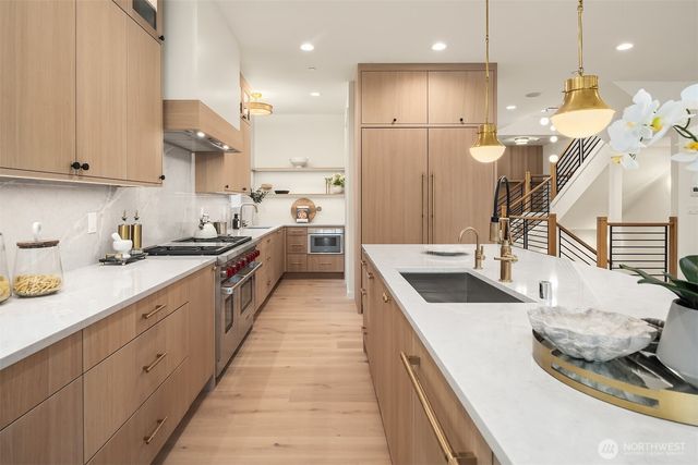 a kitchen with a large counter top a sink and a wooden floors