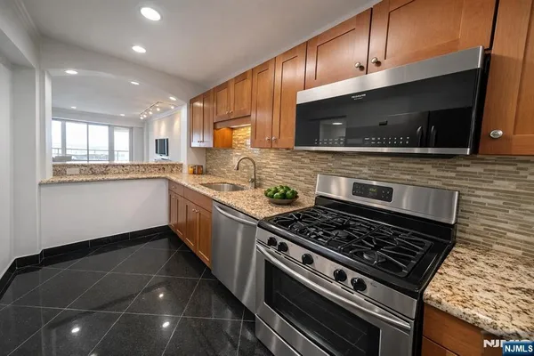 a kitchen with stainless steel appliances a sink a stove and cabinets