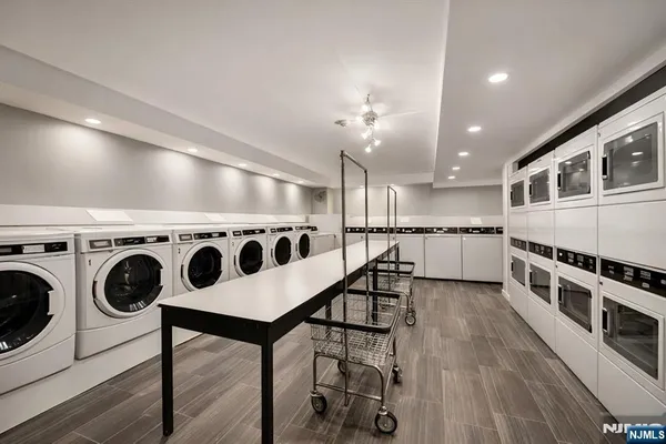 a kitchen with a stove a refrigerator and white cabinets with wooden floor