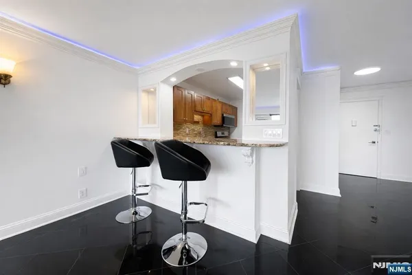 a kitchen with stainless steel appliances kitchen island granite countertop a table and chairs in it