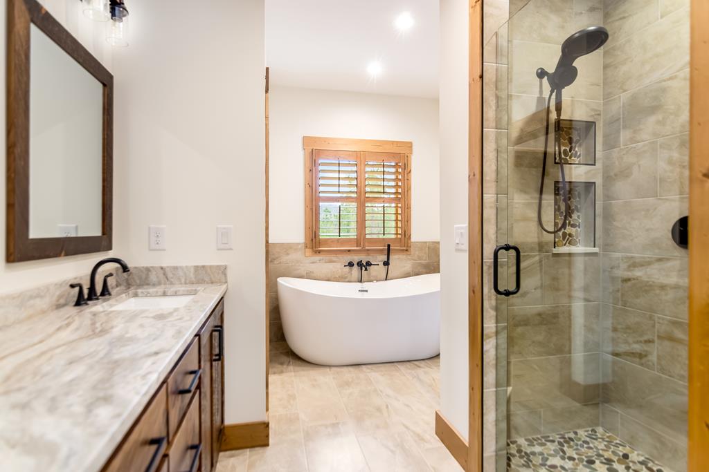 2468 Twisted Oak Road Talking Rock, GA 30175 - Photo 20 of 67 a bathroom with a granite countertop sink a mirror and shower