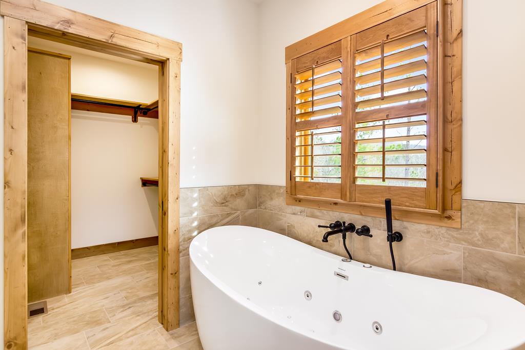 2468 Twisted Oak Road Talking Rock, GA 30175 - Photo 23 of 67 a white bath tub sitting in a bathroom next to a window