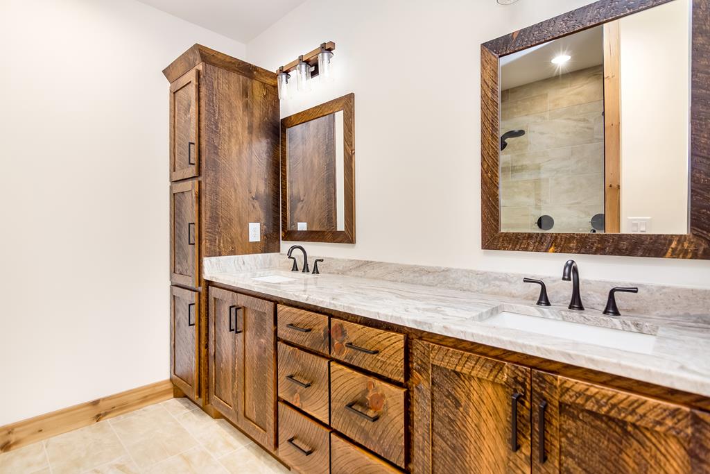 2468 Twisted Oak Road Talking Rock, GA 30175 - Photo 26 of 67 a bathroom with a double vanity sink and mirror