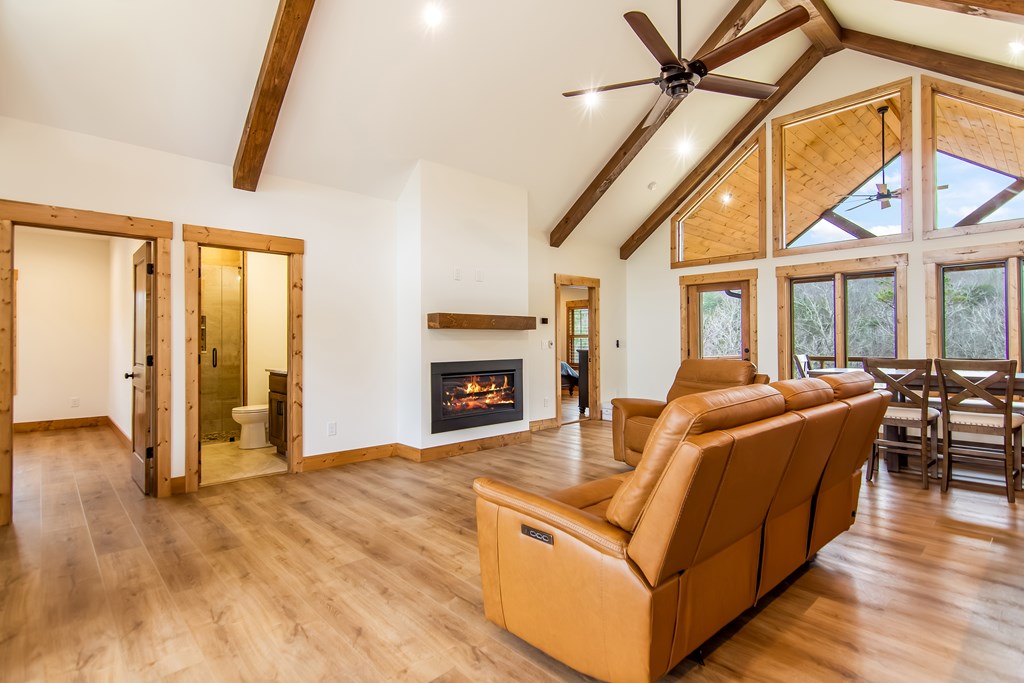 2468 Twisted Oak Road Talking Rock, GA 30175 - Photo 9 of 67 a living room with furniture a fireplace and a floor to ceiling window