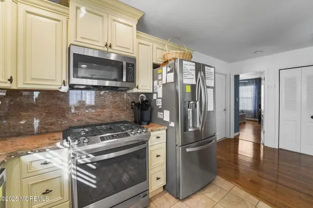 a kitchen with stainless steel appliances granite countertop a stove a refrigerator and a microwave