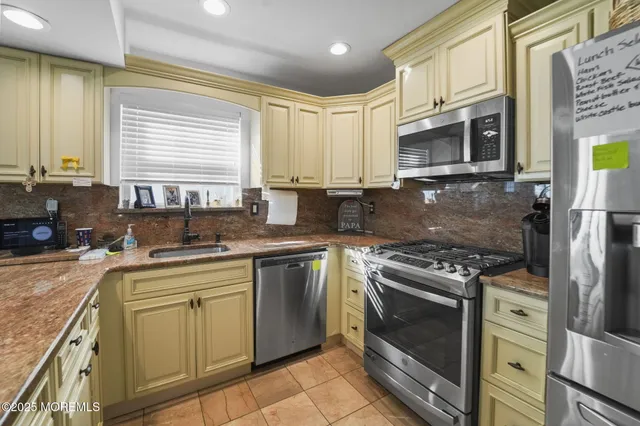 a kitchen with stainless steel appliances granite countertop a stove a sink and a microwave