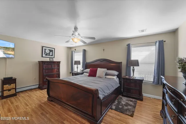 a bedroom with a large bed a flat tv screen and a dresser