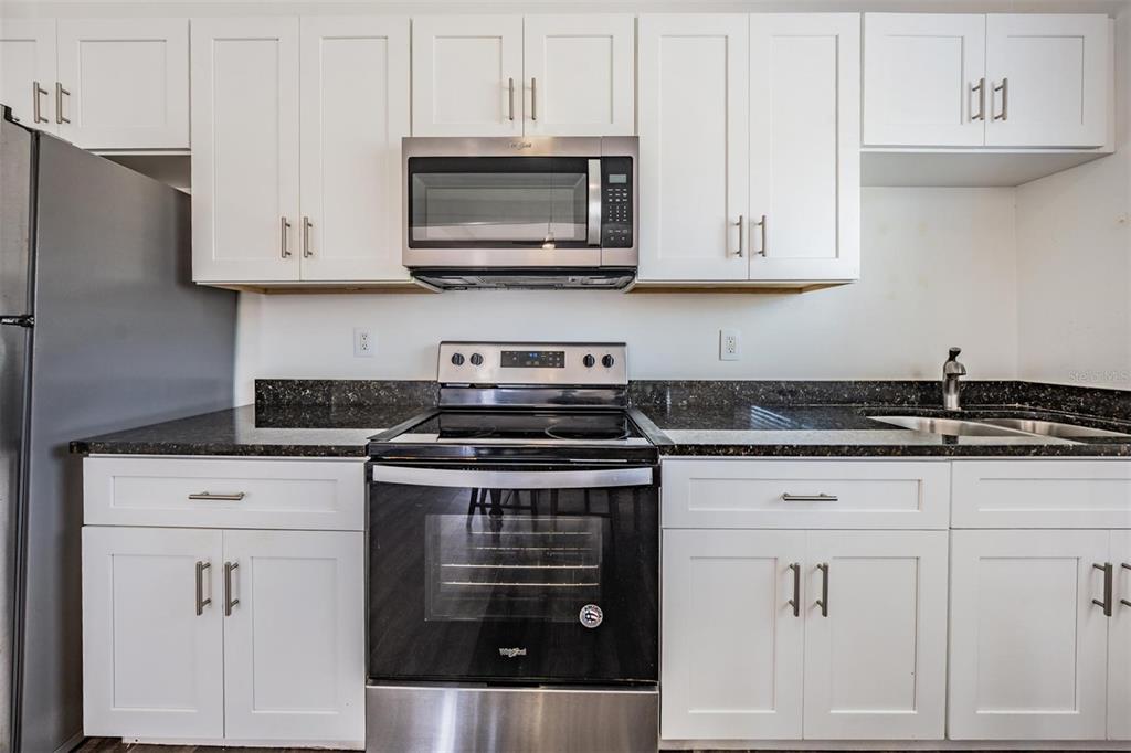 2319 West Aileen Street Tampa, FL 33607 - Photo 16 of 26 a kitchen with white cabinets and stainless steel appliances