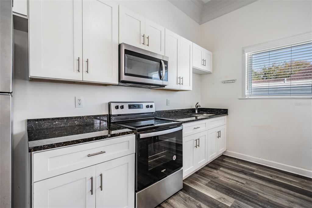 2319 West Aileen Street Tampa, FL 33607 - Photo 17 of 26 a kitchen with stainless steel appliances granite countertop white cabinets a stove a sink and dishwasher