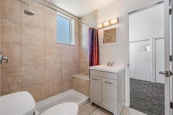 a bathroom with a sink a toilet and shower