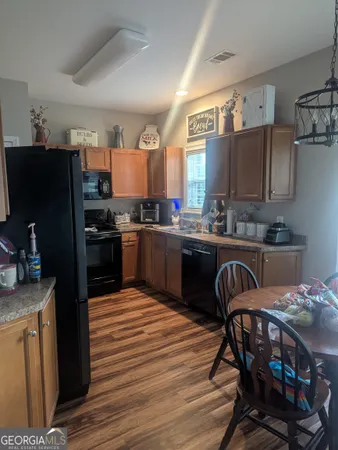 a kitchen with a table chairs refrigerator and microwave