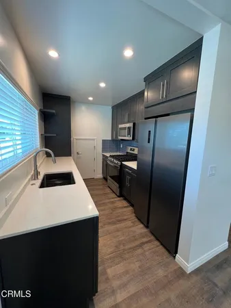 a kitchen with stainless steel appliances a refrigerator sink and microwave