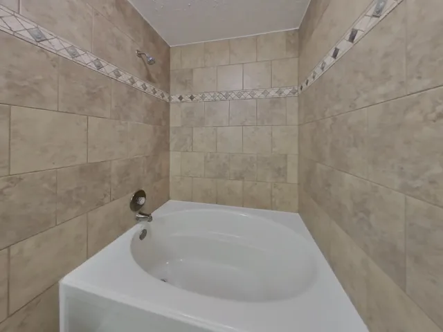 a bathroom with a granite countertop toilet sink and mirror