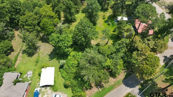 an aerial view of residential house with outdoor space and trees all around