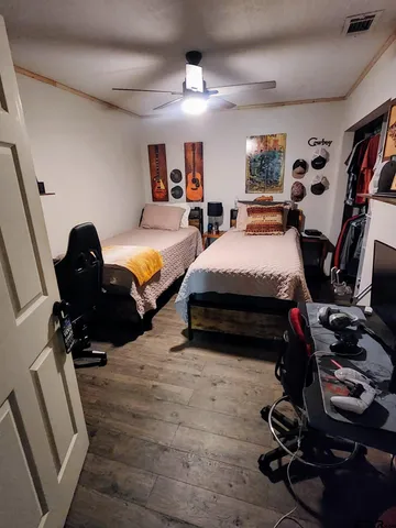 a bedroom with furniture and a wooden floor