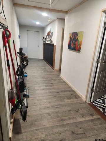 a view of a hallway with closet and a window