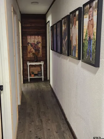 a view of a hallway with wooden floor and furniture