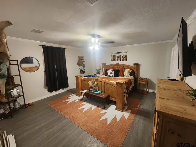 a bedroom with a bed and a flat tv screen on the dresser