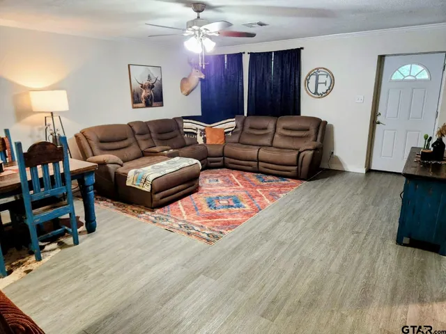a living room with furniture and a wooden floor