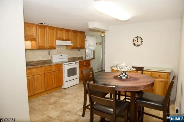 a kitchen with a dining table chairs and refrigerator