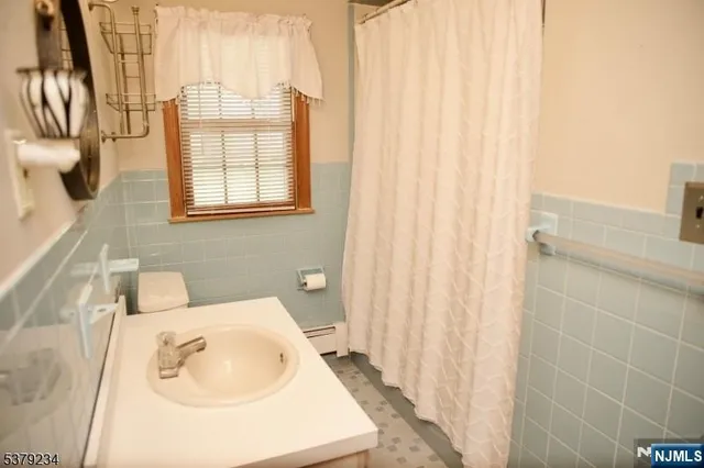 a bathroom with a sink a mirror and shower curtain