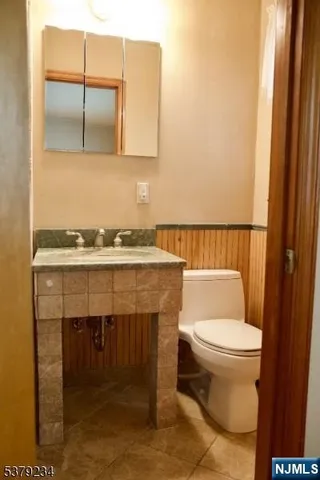 a bathroom with a toilet a sink and a mirror
