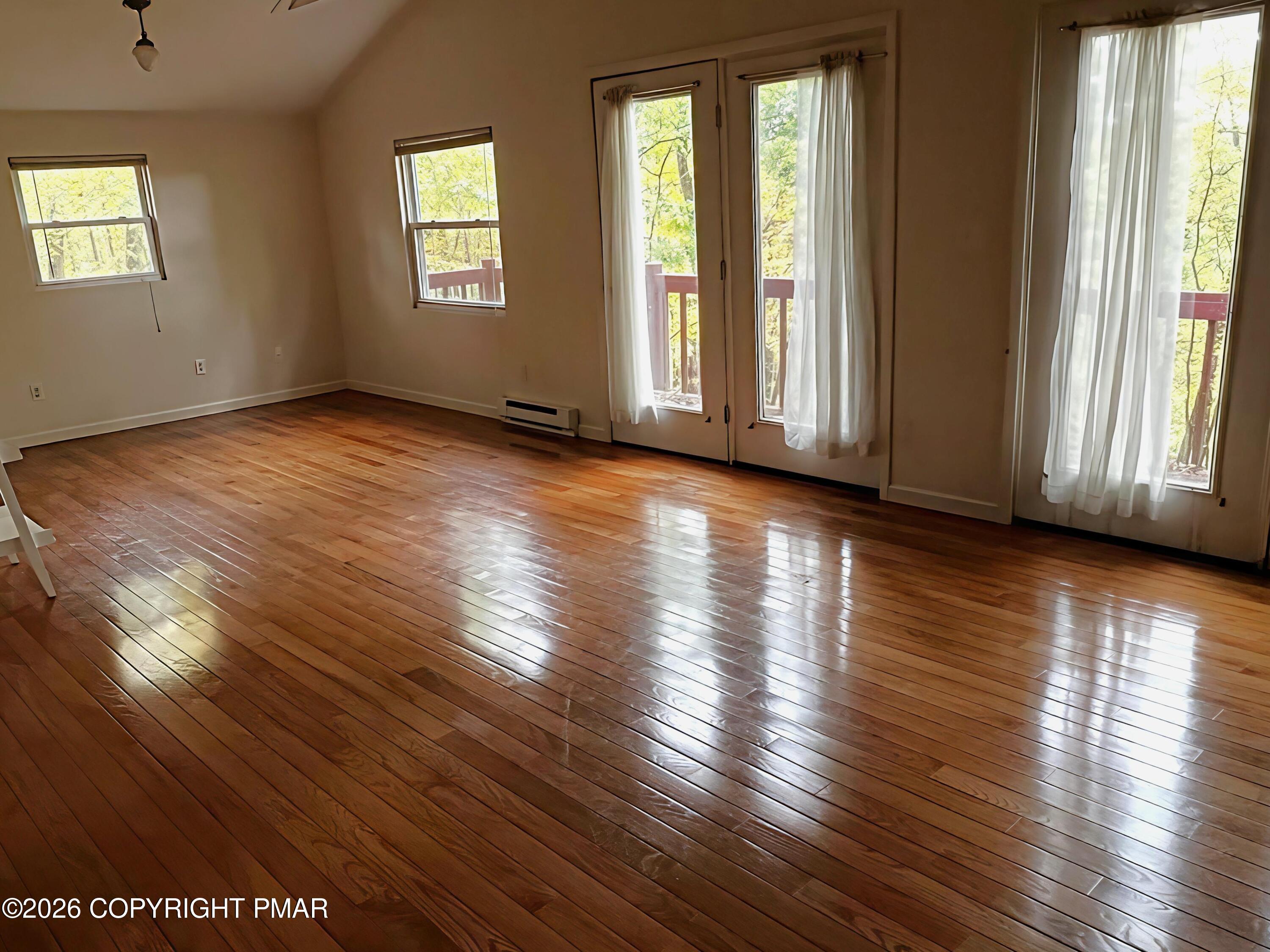 124 Saunders Drive Bushkill, PA 18324 - Photo 10 of 43 an empty room with wooden floor and windows