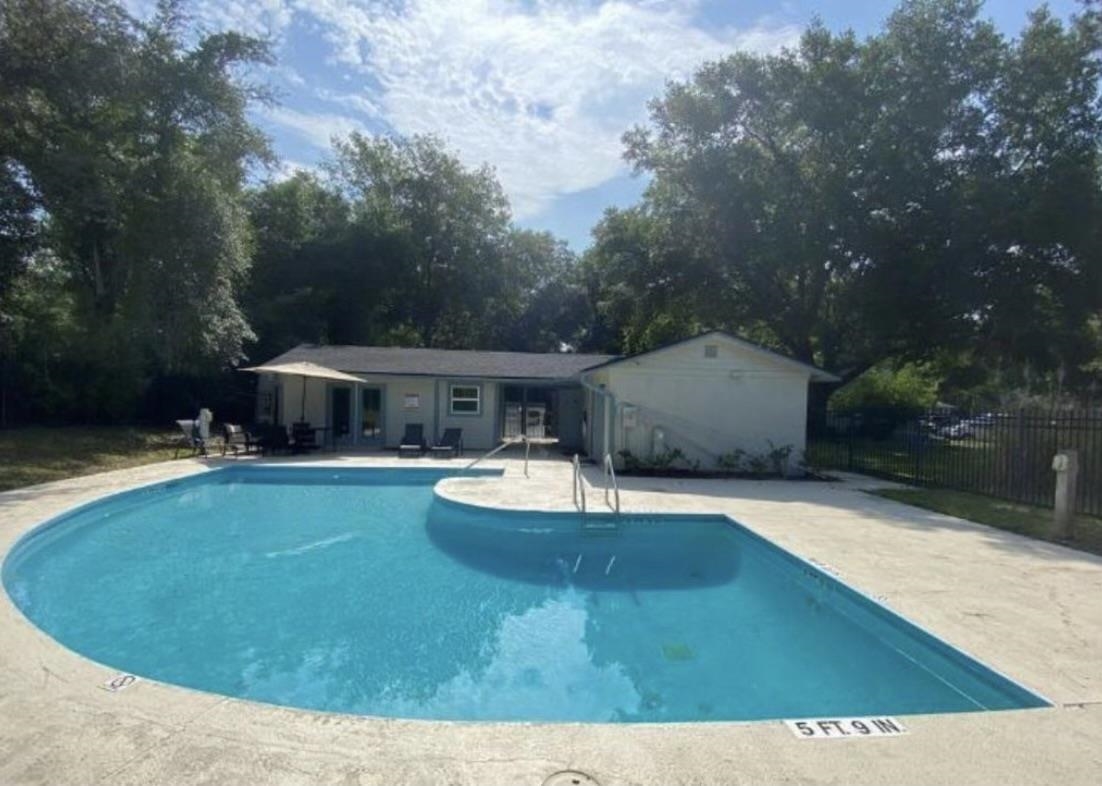 4 Moultrie Creek Circle St. Augustine, FL 32086 - Photo 5 of 55 a view of a swimming pool with lawn chairs under an umbrella