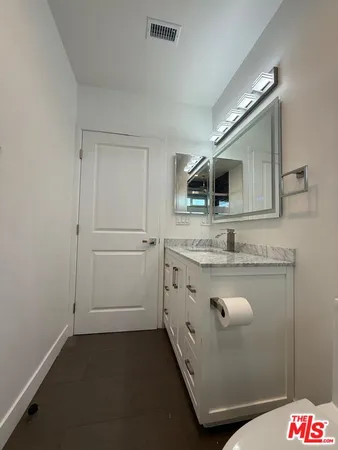 a bathroom with a granite countertop sink and a mirror