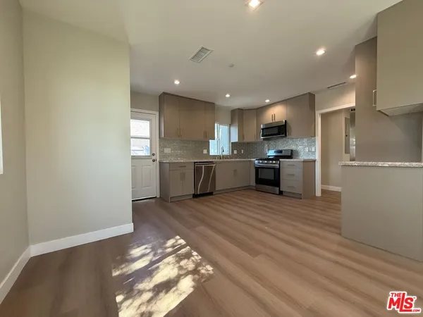 a large kitchen with stainless steel appliances granite countertop a stove and a refrigerator