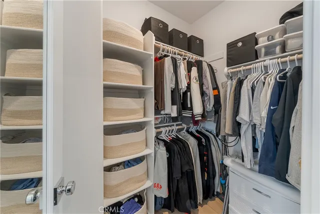 a view of walk in closet with clothes and shoes