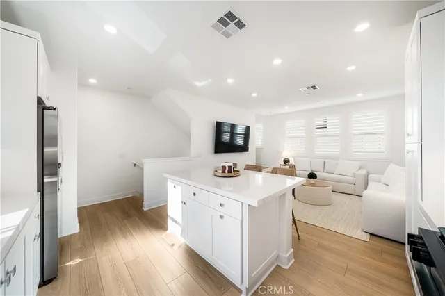 a large white kitchen with a stove top oven a sink and dishwasher