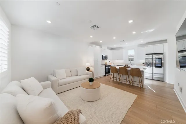 a living room with lots of furniture and view of kitchen
