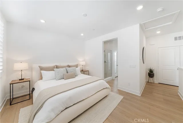 a spacious bedroom with a bed and a lamp