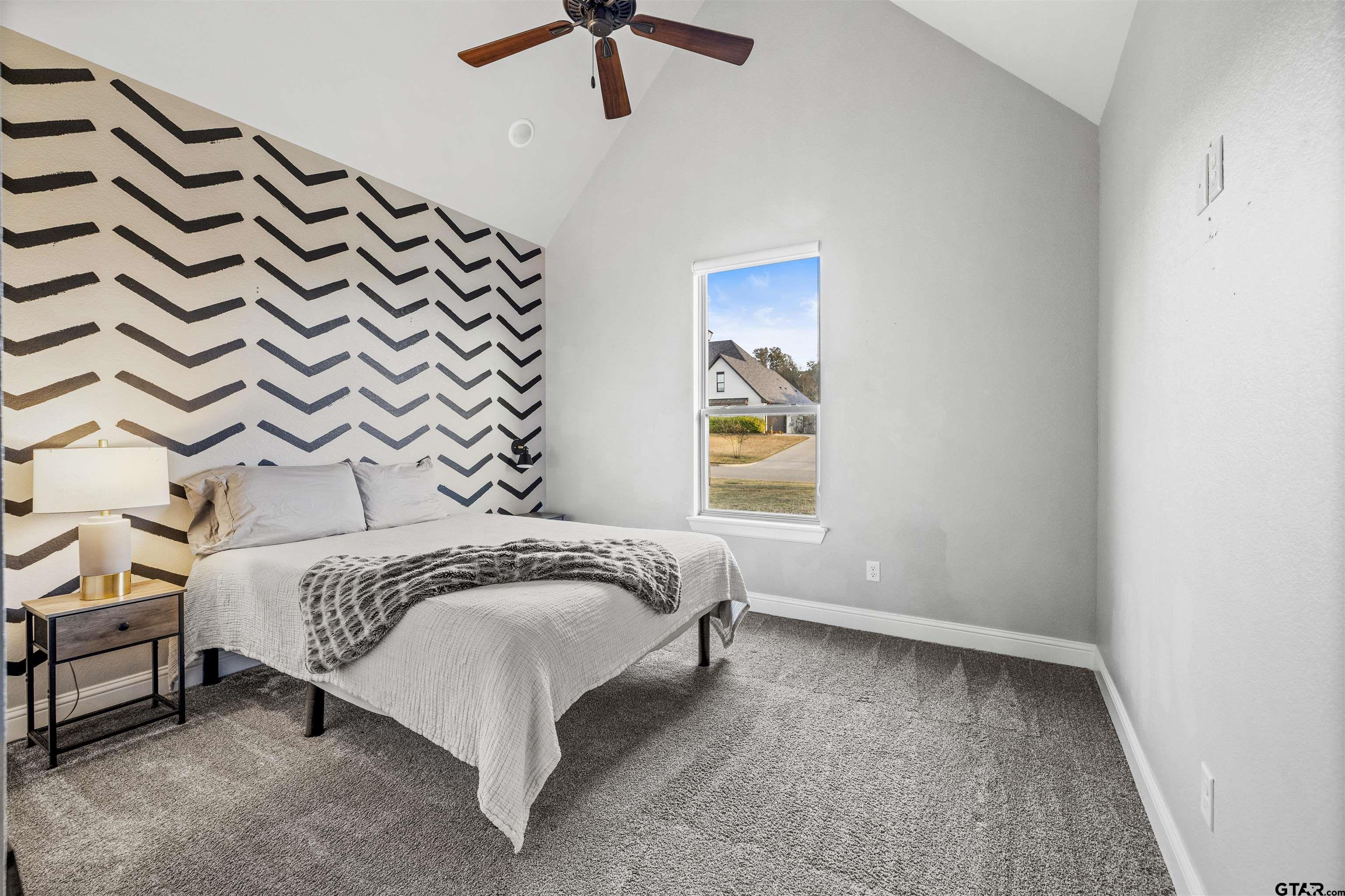 425 Coventry Street Bullard, TX 75757 - Photo 18 of 35 a bed sitting in a room next to a lamp and a window