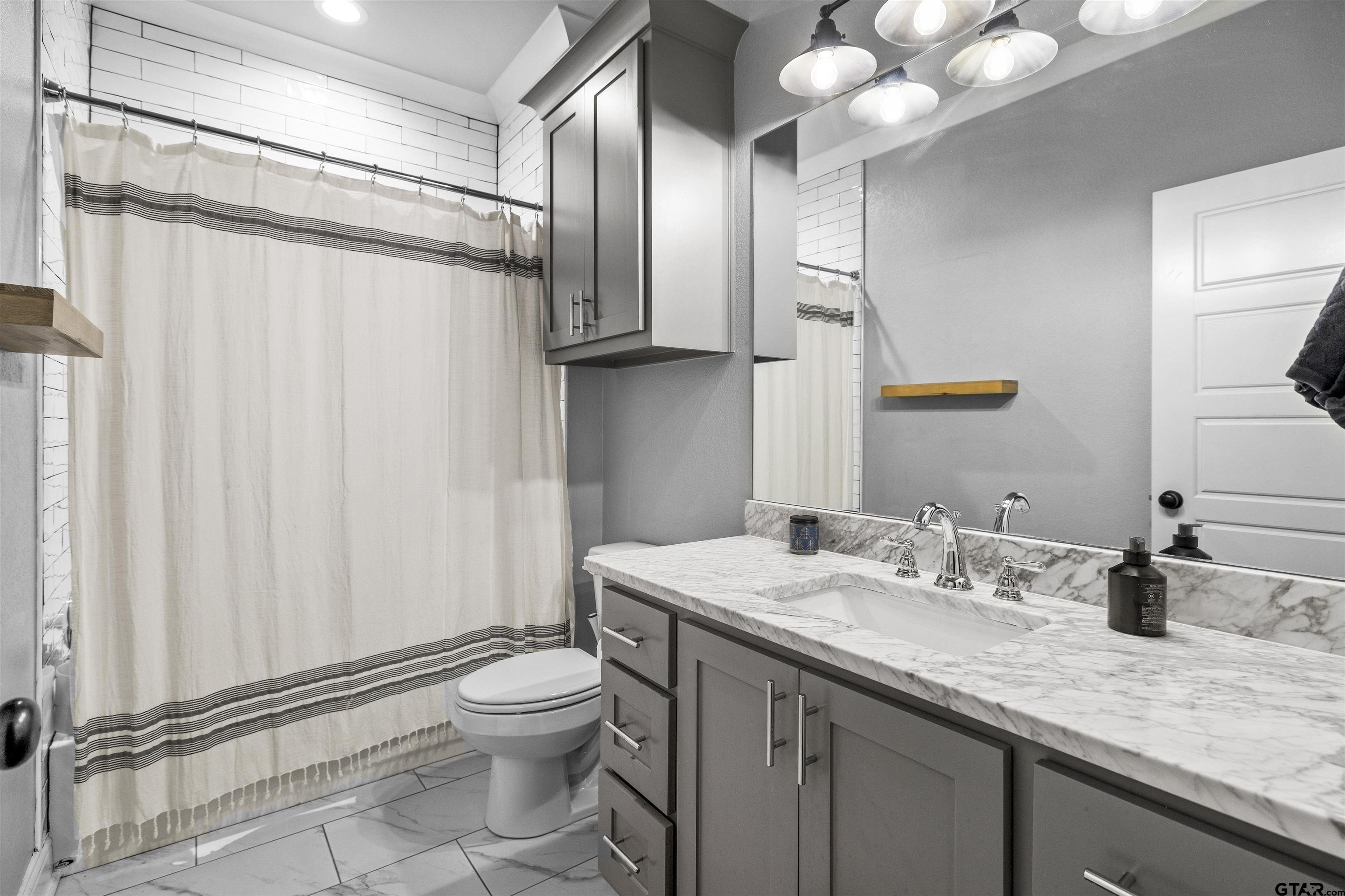 425 Coventry Street Bullard, TX 75757 - Photo 21 of 35 a bathroom with a granite countertop sink a toilet and a mirror