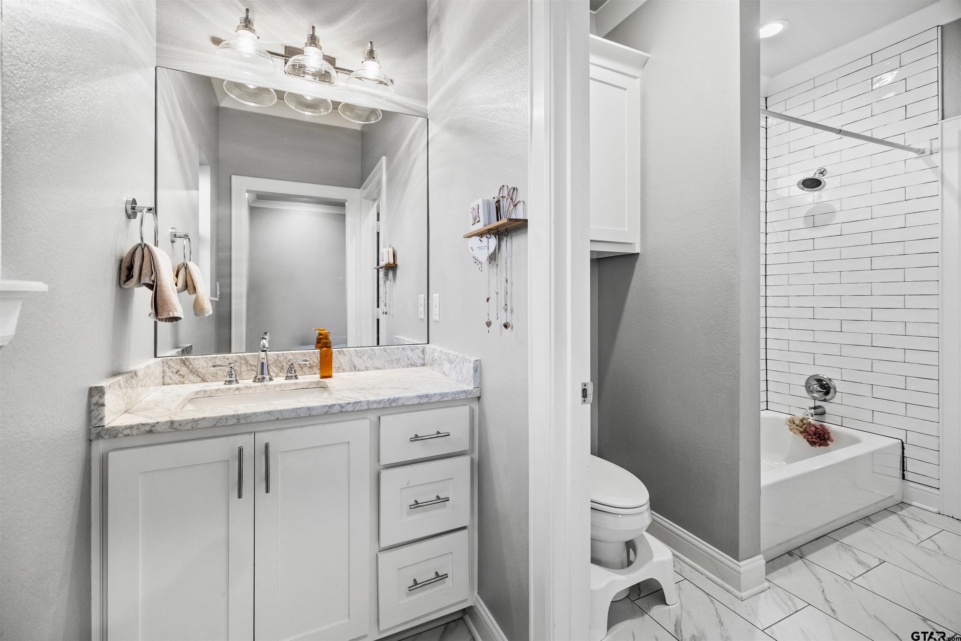 425 Coventry Street Bullard, TX 75757 - Photo 23 of 35 a spacious bathroom with a granite countertop sink a toilet a mirror and shower