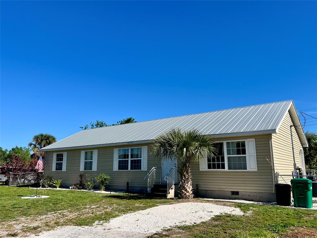8971 Southeast 67th Drive Okeechobee, FL 34974 - Photo 2 of 14 a front view of a house with garden