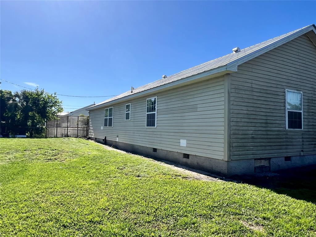 8971 Southeast 67th Drive Okeechobee, FL 34974 - Photo 4 of 14 a view of a backyard with plants and large trees
